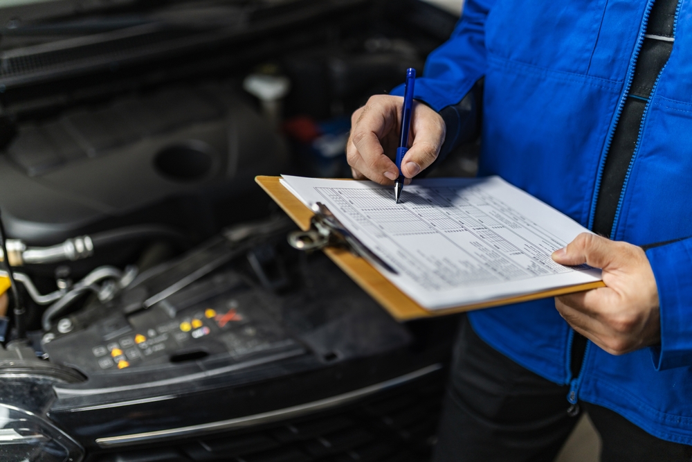 Tehnician efectuând un control preventiv al unui autoturism Suzuki